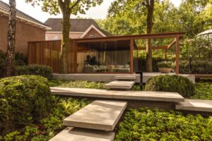 Bij Villa Arte in Laren werd een volwassen boom het kloppende hart van een nieuwe buitenruimte. Dankzij de modulaire overkapping van Amani en Renson Outdoor ontstond een luxueuze cocon waarin natuur en architectuur elkaar versterken.