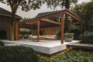 Bij Villa Arte in Laren werd een volwassen boom het kloppende hart van een nieuwe buitenruimte. Dankzij de modulaire overkapping van Amani en Renson Outdoor ontstond een luxueuze cocon waarin natuur en architectuur elkaar versterken.