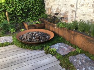 Hergebruik van natuursteen blijft relevant binnen hedendaagse tuinprojecten. Deze blauwe hardsteen met gekloven bovenzijde combineert circulair materiaalgebruik met een uitgesproken oppervlaktestructuur.